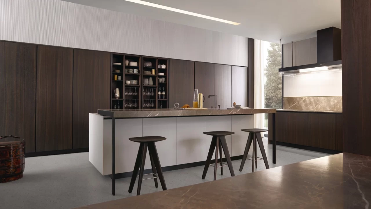 A luxury open kitchen layout featuring a dark stone dining table and olive green upholstered chairs, illustrating seamless dining furniture placement in a modern open-plan home.